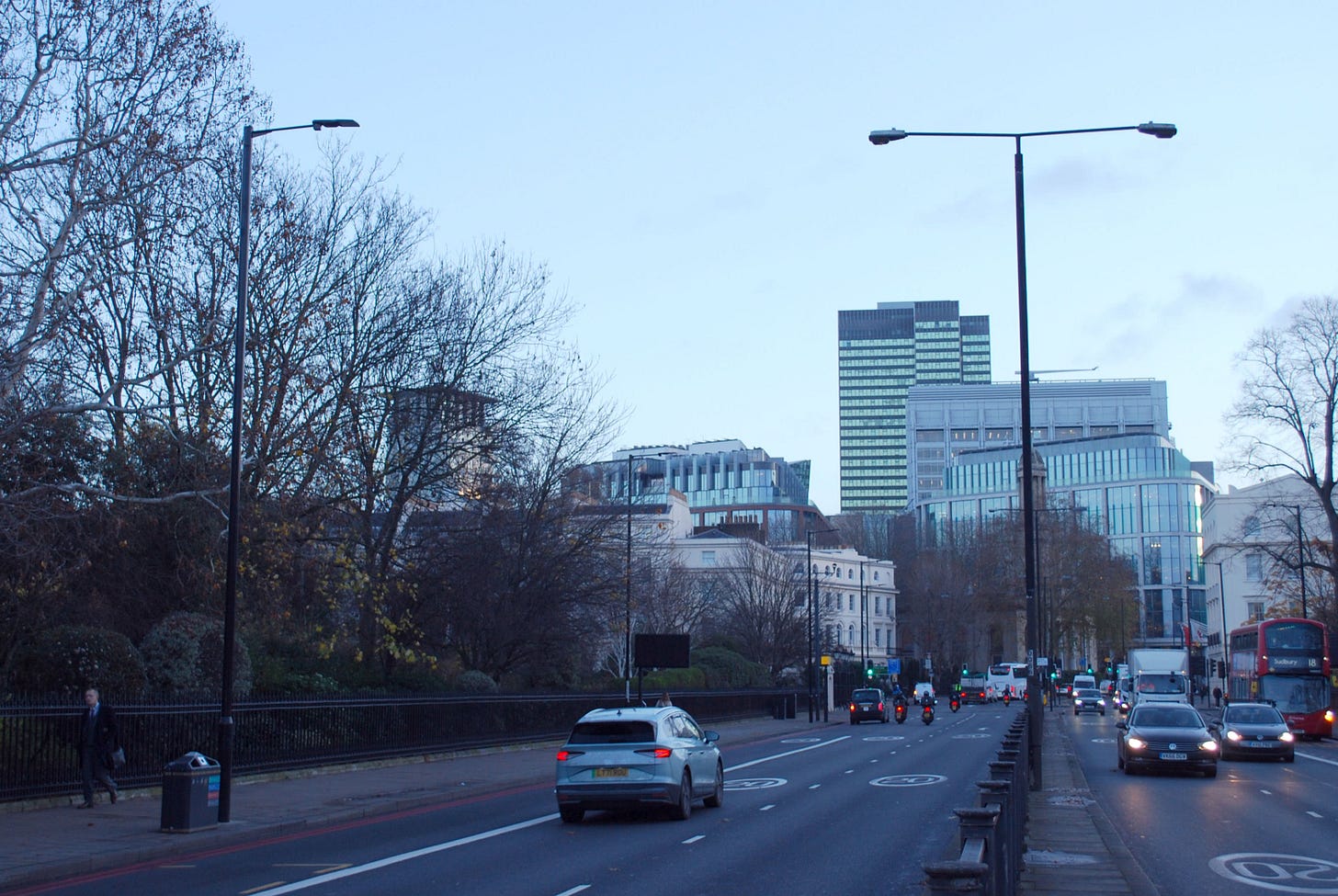 Photograph looking along Marylebone Road, a dual carriageway with moving traffic. Two street lights are in view, one in the central reservation with twin arms, and another brand new light on the left of the road