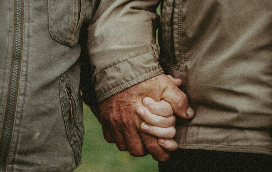 a close up of two people holding hands