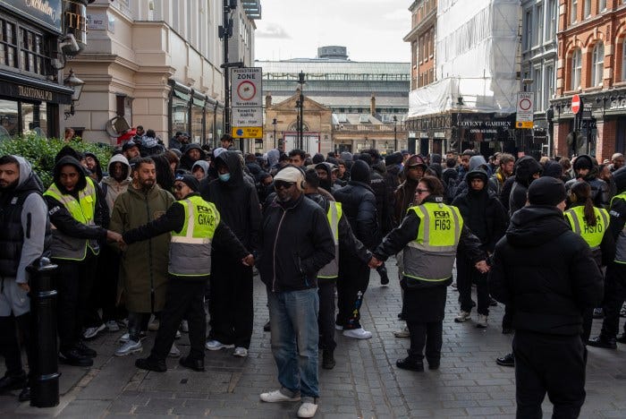 Security guards holding back a large crowd outside a Swatch store in Covent Garden, London. Security guards holding back a large crowd outside a Swatch store in Covent Garden, London.