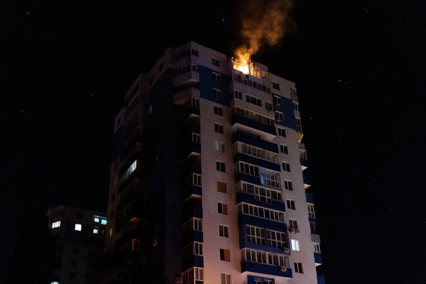 A damaged residential building is seen on fire following a drone strike in Ukraine.