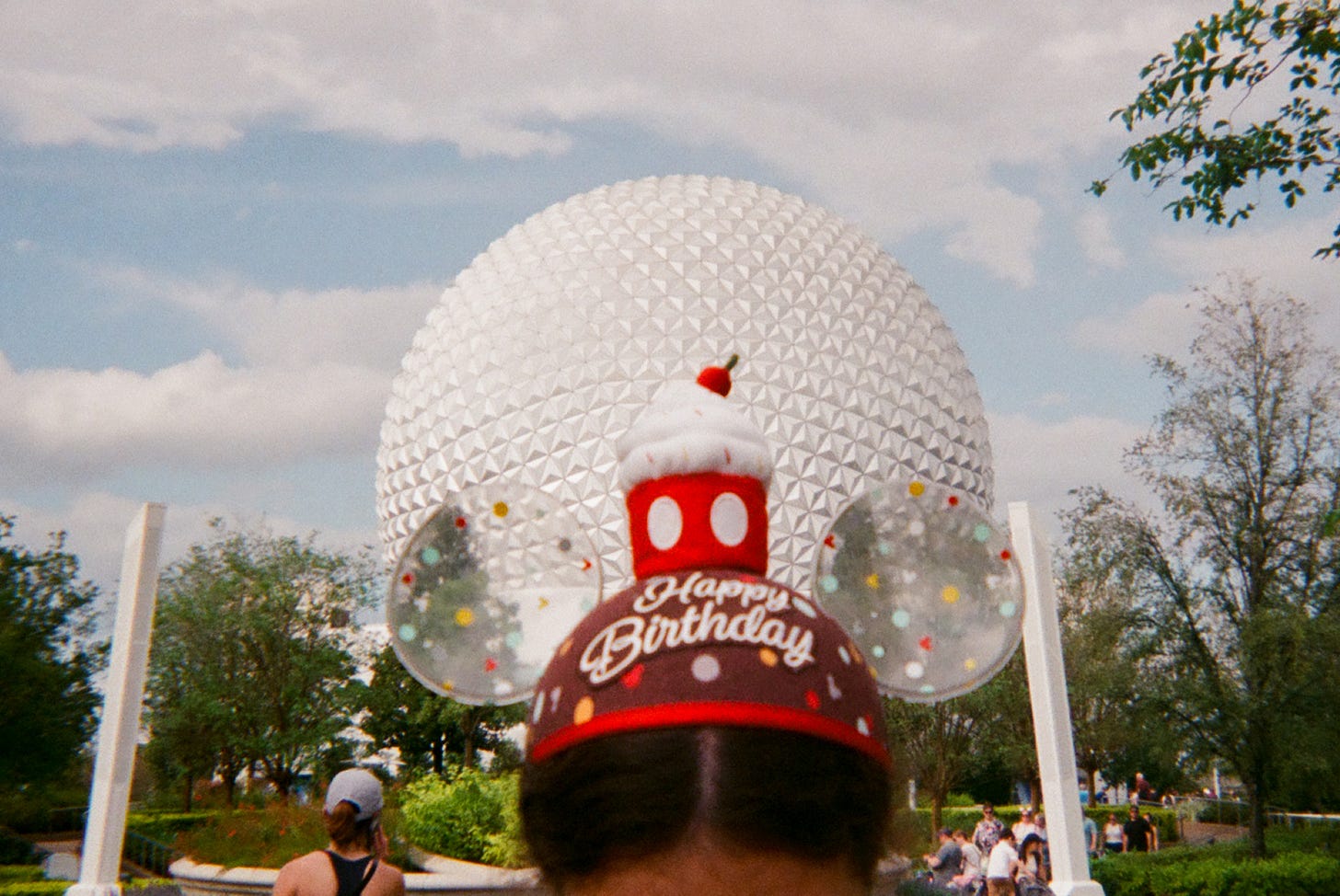 Me wearing my Disney birthday hat in front of Spaceship Earth at EPCOT.