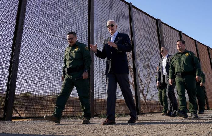 A person in a suit walking next to a fence
Description automatically generated A person in a suit walking next to a fence
Description automatically generated
