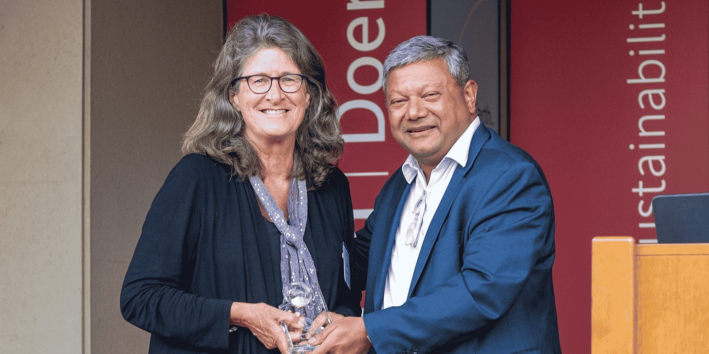 Jane Woodward smiles with Arun Majumdar holding the Alumni Award Jane Woodward smiles with Arun Majumdar holding the Alumni Award