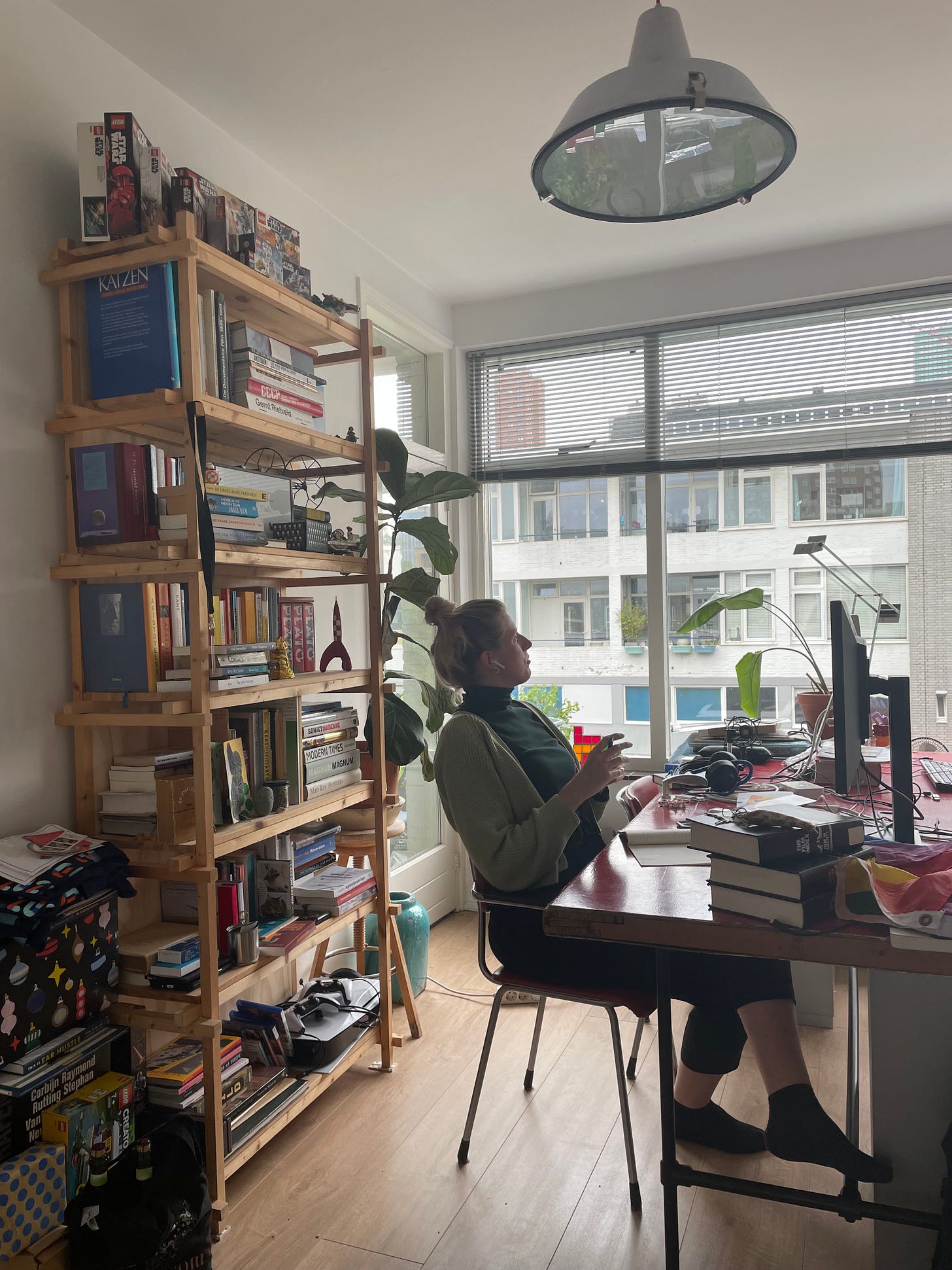 foto van een vrouw die achter een bureau zit en naar buiten kijkt