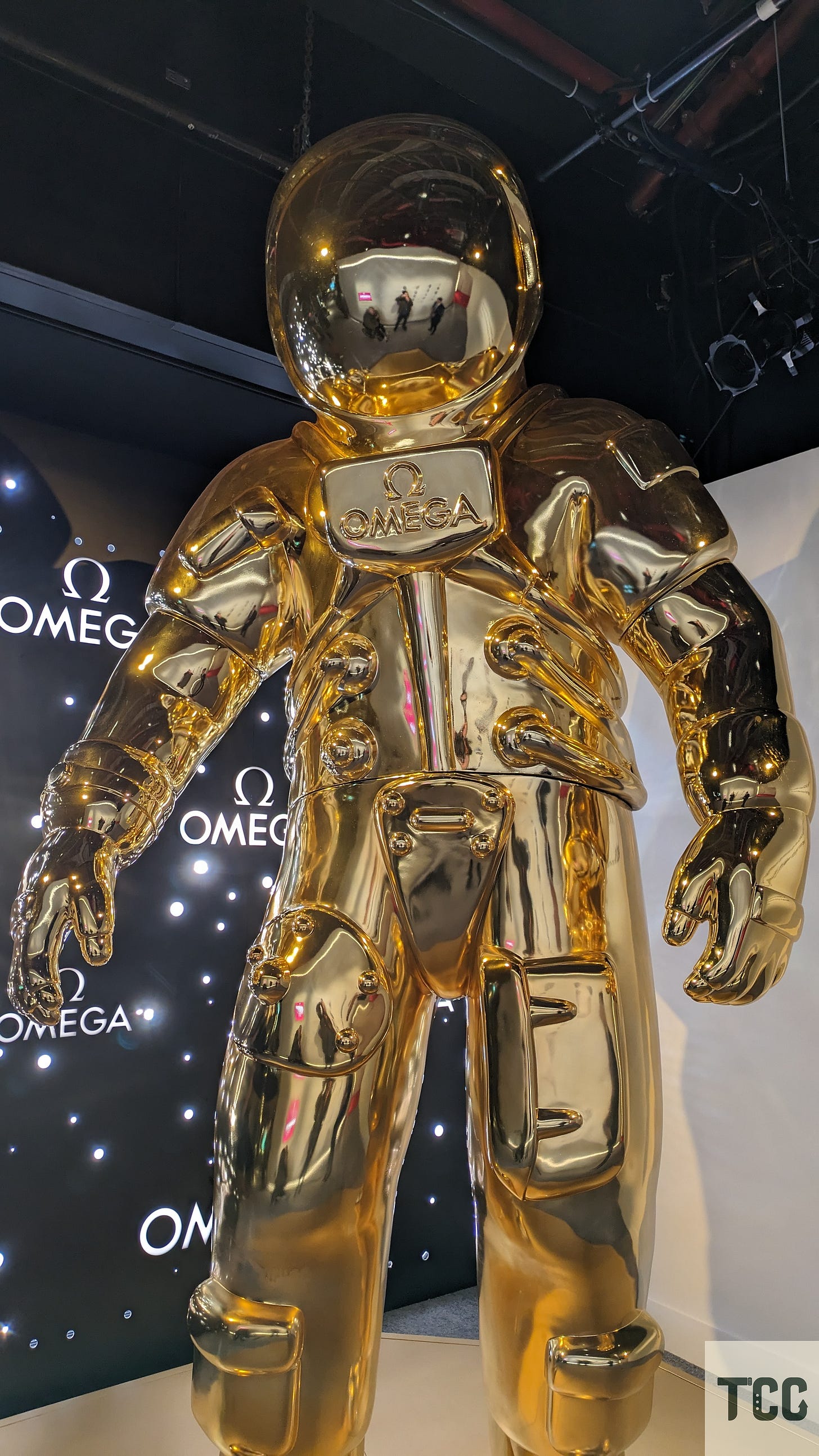 A giant gold astronaut with OMEGA branding.