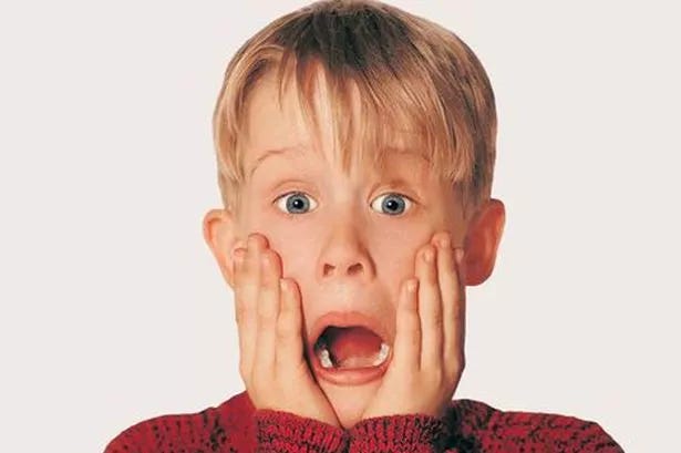ator macaulay culkin no filme esquecendo de mim, com as duas mãos na bochecha, olhos arregalados e boca aberta
