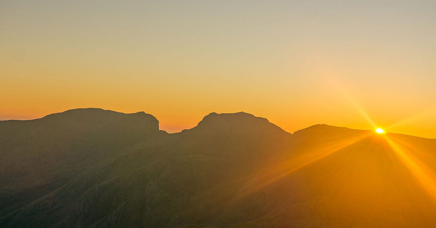 two mountains, sun setting behind