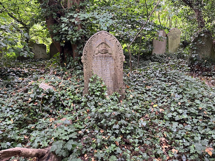 Six headstones with inscriptions of handshakes in a woodland cemetery