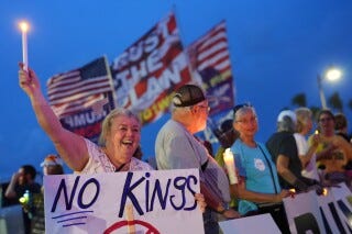 Dee Cahill of Margate, Fla., holds a "No Kings" sign as she participates in a pro-democracy, anti-Trump protest outside Trump's Mar-a-Lago estate in Palm Beach, Fla., Thursday, July 17, 2025. (AP Photo/Rebecca Blackwell, File)