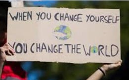 A photo of a person holding a sign saying "When you change yourself, you change the world"