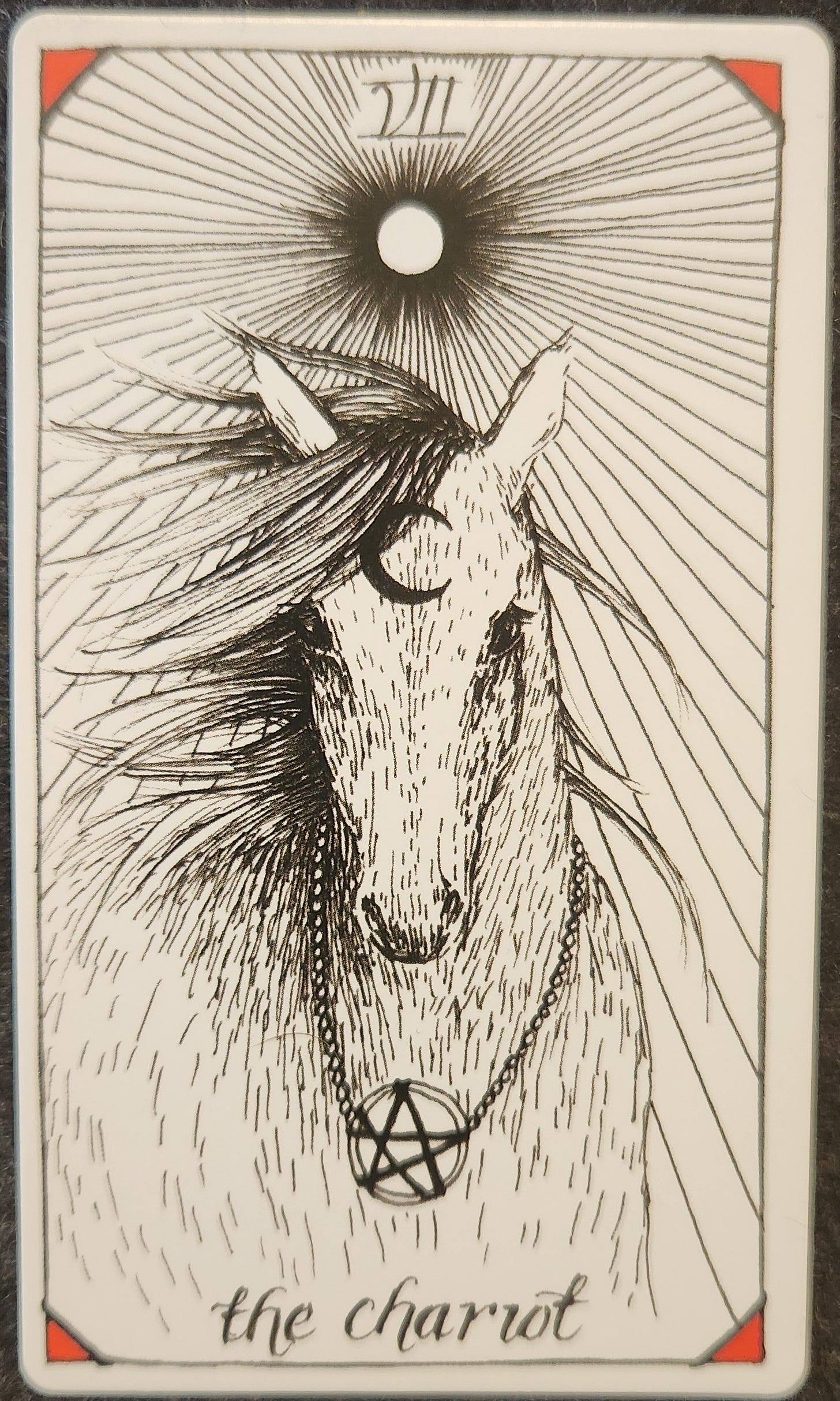A tarot card labelled XII the chariot. A wild horse is looking directly forward, its mane strewn around. They have a crescent moon on their forehead and a pentacle necklace around their neck. Above is a full sun shining down on them.