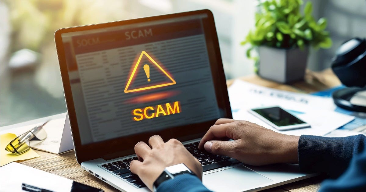 Man typing on a laptop with the word scam on the screen representing job scams.