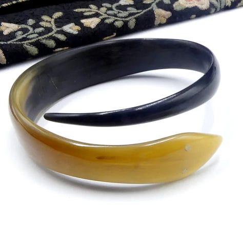 Stylized snake forms beginning in horn or shell are remade in early plastic approximations of natural materials.