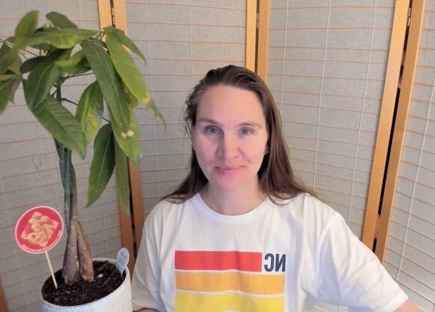 Smiling lady in rainbow shirt with money tree Smiling lady in rainbow shirt with money tree