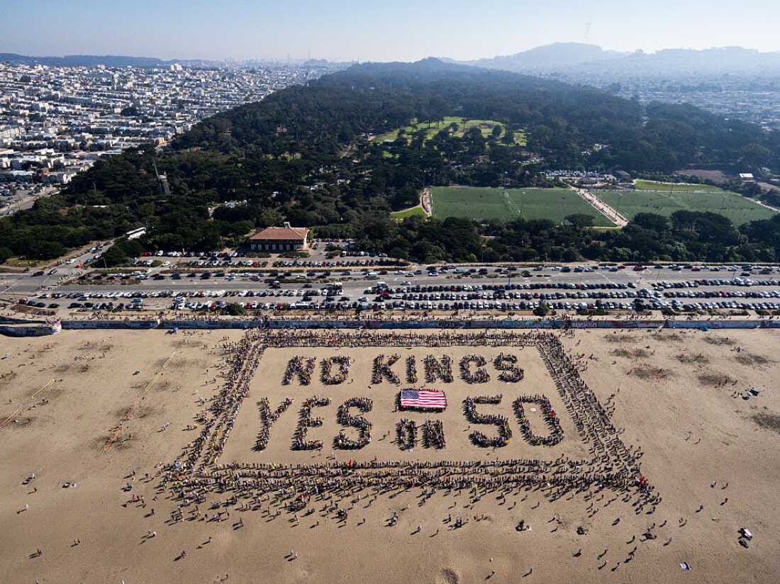 This aerial picture shows protesters forming a human banner during the "No Kings" national day of protest on Ocean Beach in San Francisco, Calif. on Oct. 18, 2025.