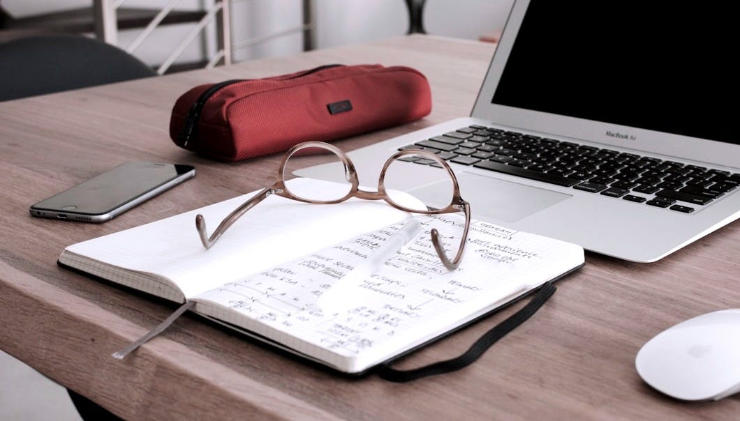 eyeglasses on book beside laptop eyeglasses on book beside laptop