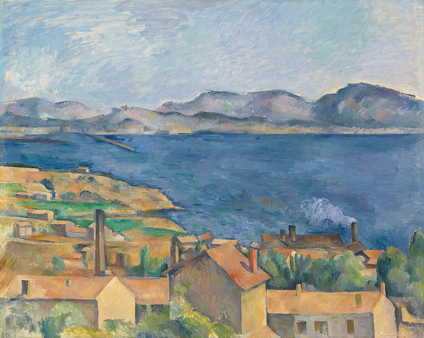 Orange-red rooftops in the foreground give way to a wide band of deep blue sea, a line of gray-blue hills and a pale sky.