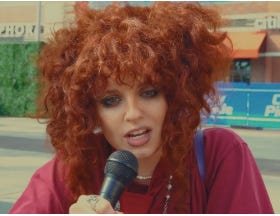 Sophie Hunter, a rapper with curly red hair on the microphone