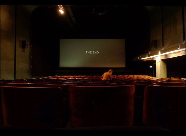 This may contain: an empty theater with rows of seats and a projector screen