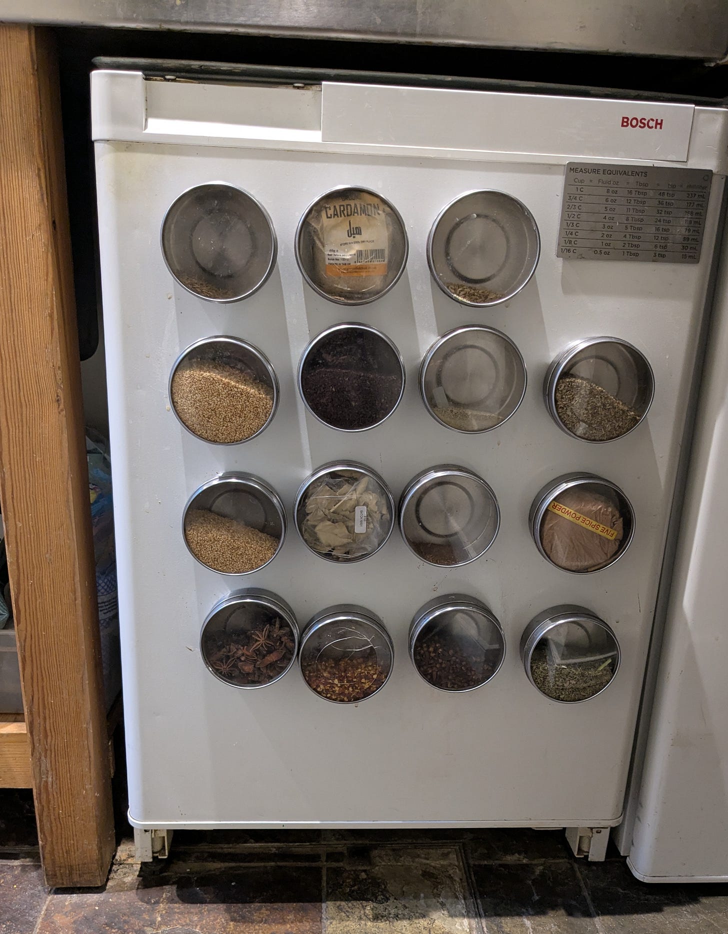 Fridge door with magnetic spice containers attached to it. Fridge door with magnetic spice containers attached to it.