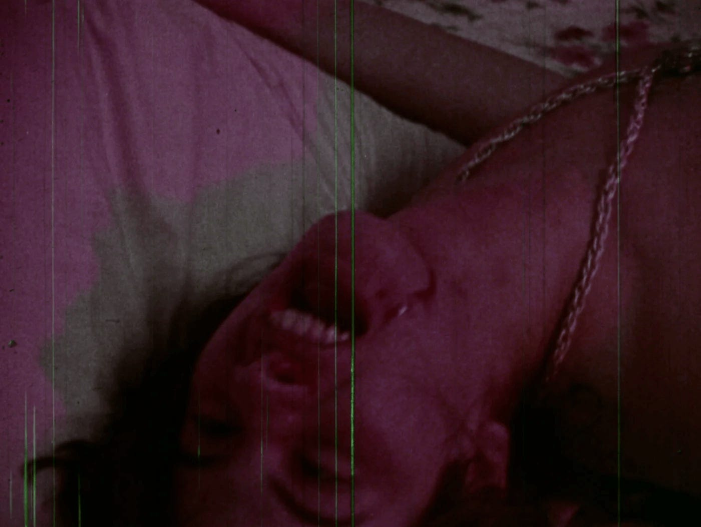 A young man on lying on a bed, his head resting on the edge of it, laughing maniacally. A young man on lying on a bed, his head resting on the edge of it, laughing maniacally.