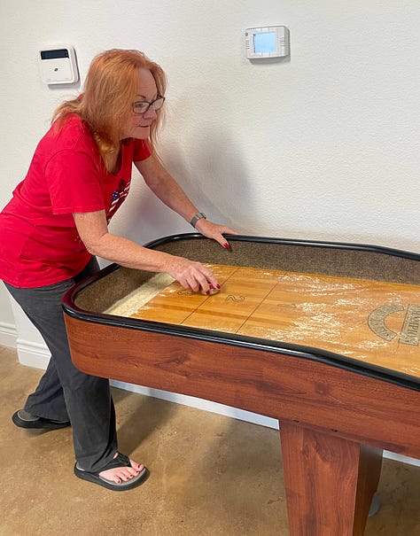 photo of Jill getting the shuffleboard ready for play and her and i playing.