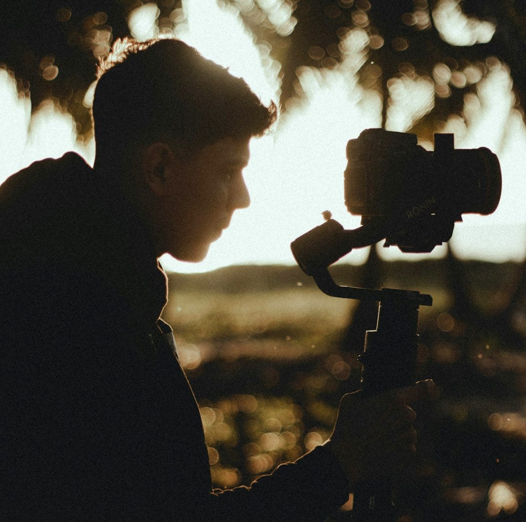 silhouette of man holding camera during sunset silhouette of man holding camera during sunset