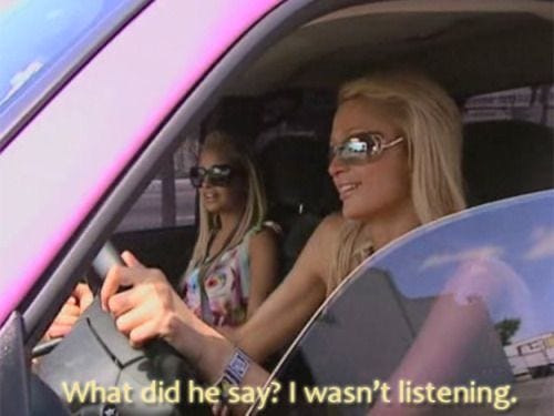 This may contain: two women sitting in a car and one is pointing at something