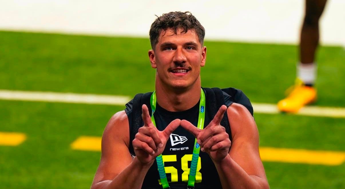 Wisconsin Badgers linebacker Mason Reiger flashes a “W” during the NFL Scouting Combine. 