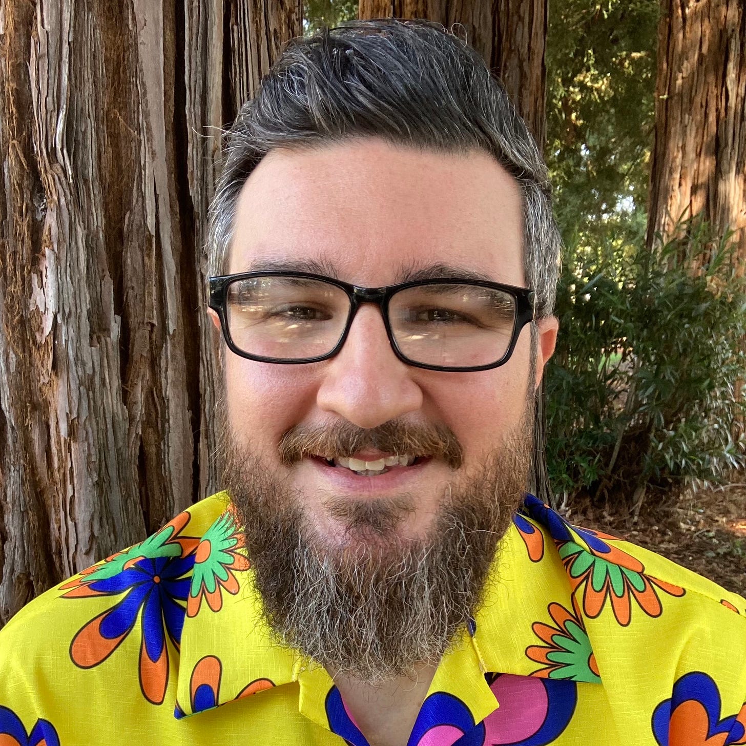 white man with glasses, beard and yellow shirt