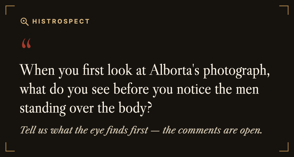 When you first look at Alborta's photograph, what do you see before you notice the men standing over the body? When you first look at Alborta's photograph, what do you see before you notice the men standing over the body?
