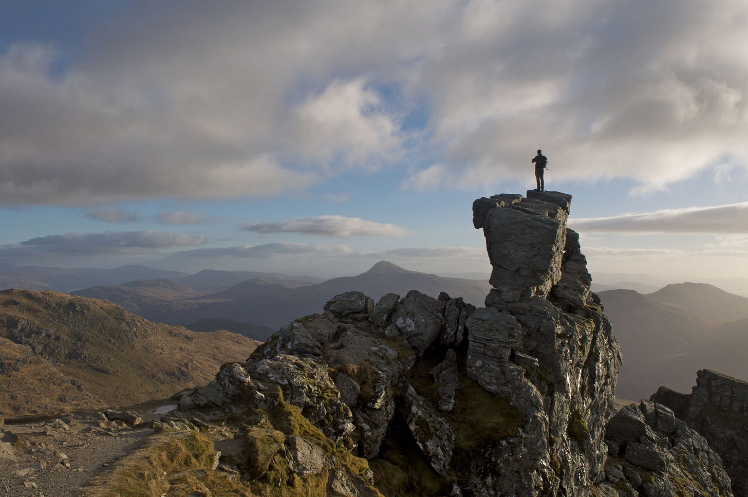 man on rock pinnacle, daybreak