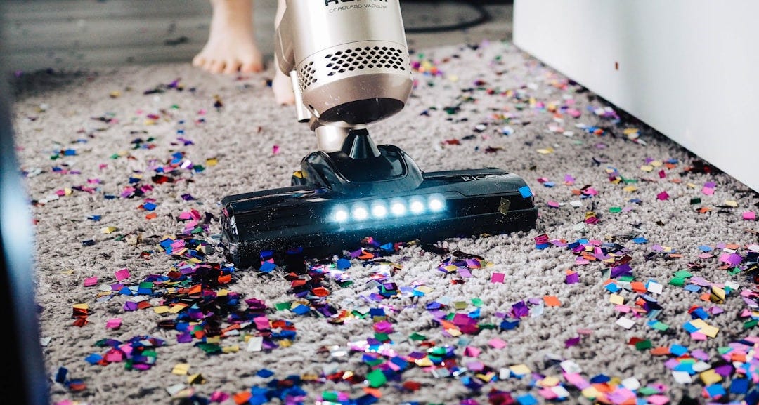 a person using a vacuum to clean a carpet a person using a vacuum to clean a carpet