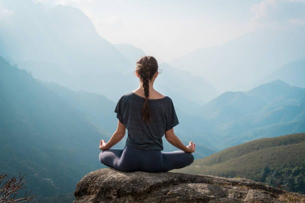 Woman meditates in yoga asana Padmasana Woman meditates in yoga asana Padmasana - Lotus pose on mountain cliff peace of mind stock pictures, royalty-free photos & images