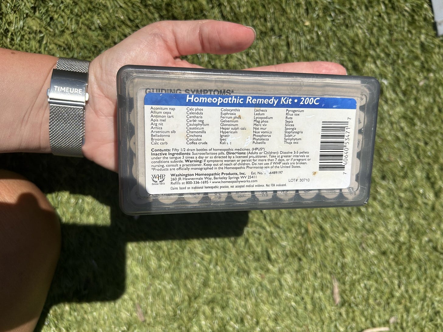 A homeopathic remedy kit resting on an open palm, showing how small a 30-to-50 remedy kit really is.