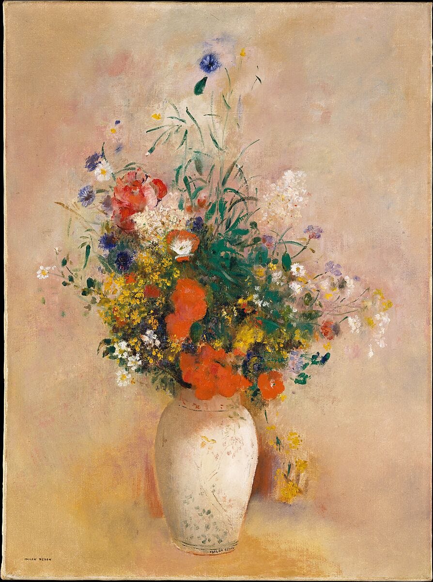 A vase of colorful flowers including pink blooms against a soft pink background A vase of colorful flowers including pink blooms against a soft pink background