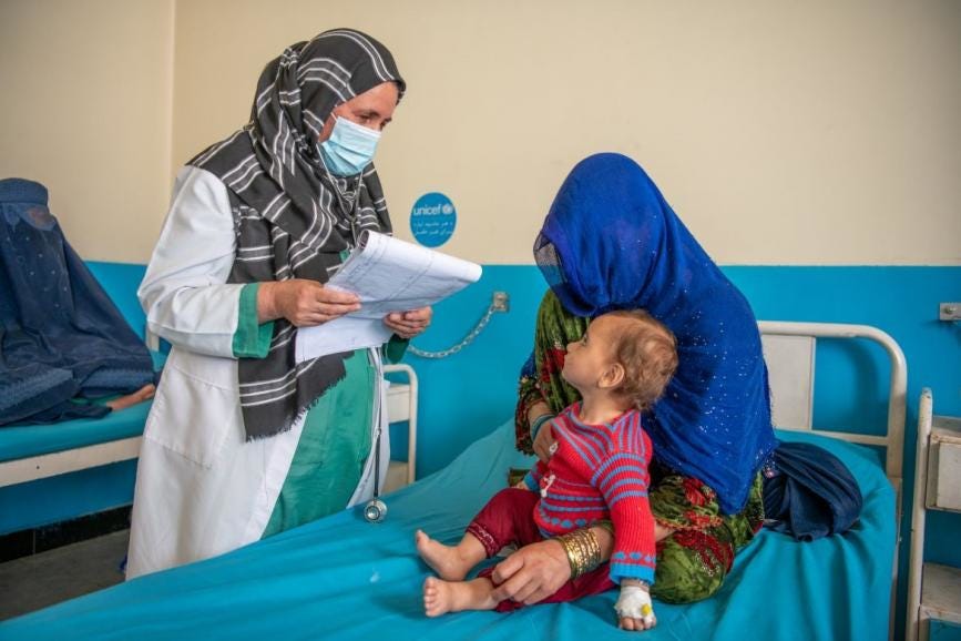 Healthcare professional consulting patient and child in an Afghan hospital supported by UNICEF amid healthcare funding challenges