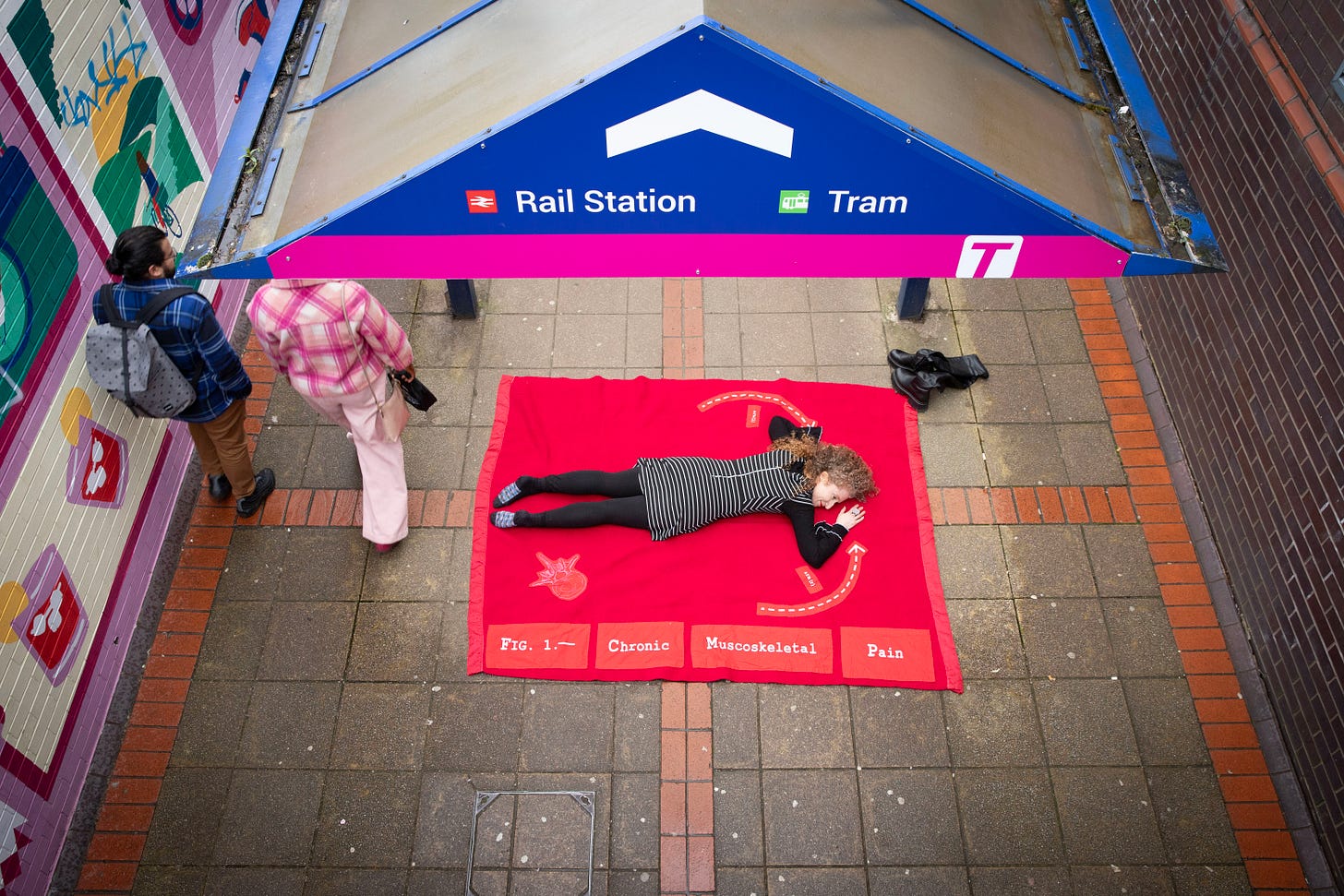 Installation of a station with a woman on the floor and the text chronic muscoskeletal pain