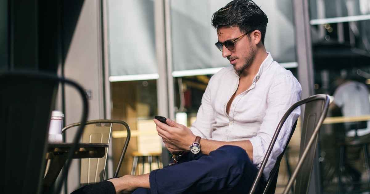 Young man sitting in a café and texting on smart phone