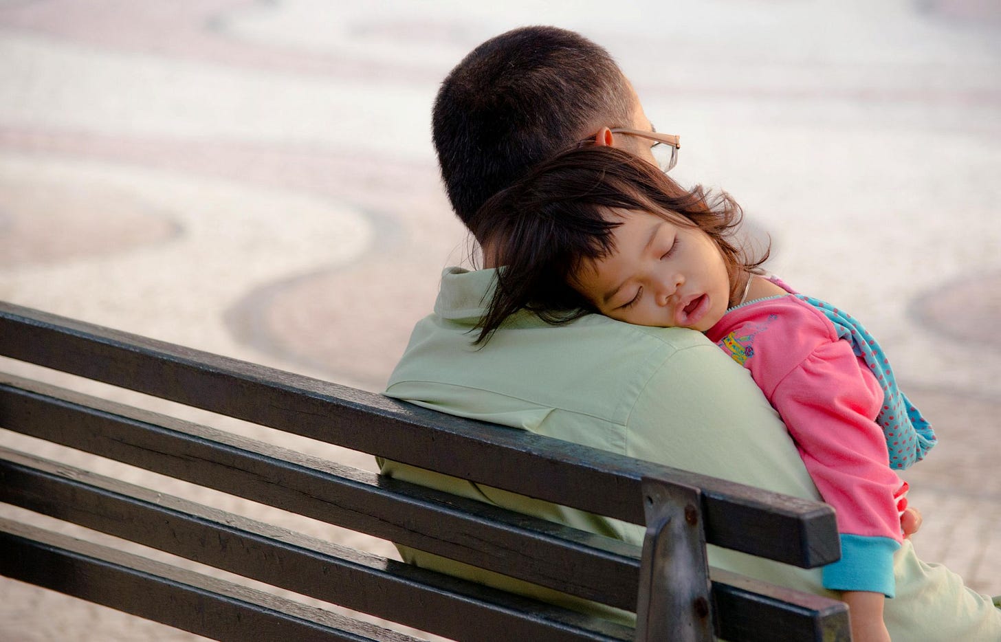 Child sleeping on her father’s shoulder. Child sleeping on her father’s shoulder.