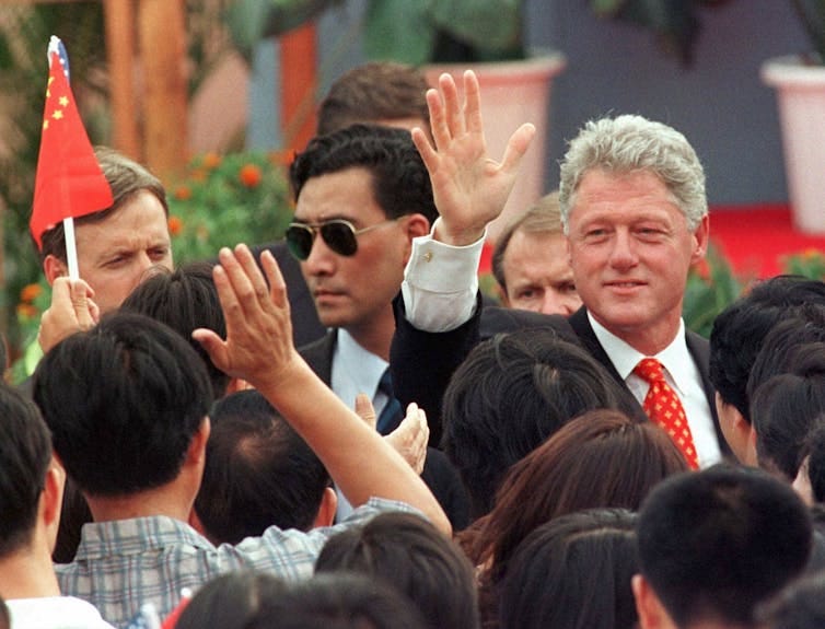 Man in suit waves to a crowd of people. Man in suit waves to a crowd of people.