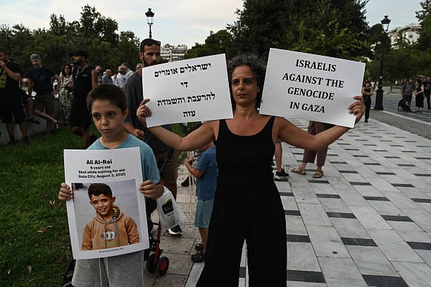 An Israeli citizen holds placard as she take part in a pro-Palestinian rally against Israel's actions and ongoing food shortages in the Gaza Strip,...