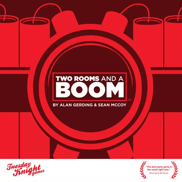 The box cover of Two Rooms and a Boom. Title in a circle strapped to red dynamite.