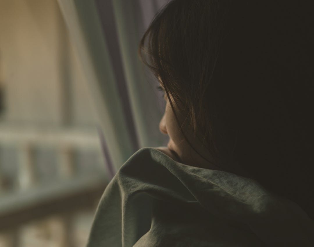woman in black shirt looking at window
