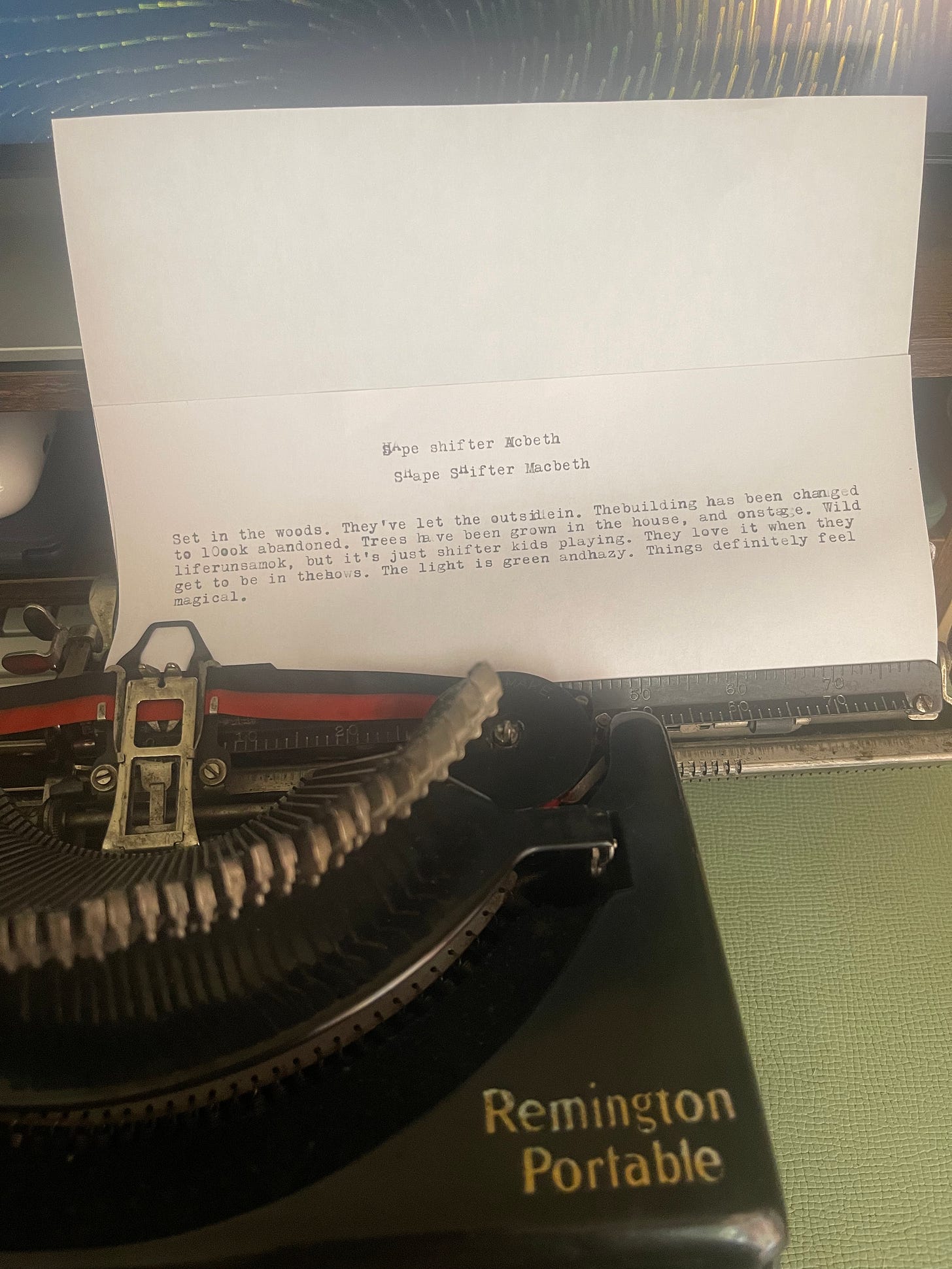 A partially typed piece of paper in an antique black typewriter in front of a green background. A partially typed piece of paper in an antique black typewriter in front of a green background.
