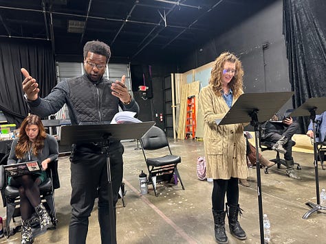 Actors reading a play in a theater.