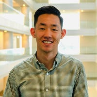Kenta smiling, standing in the Capital One office where he used to work