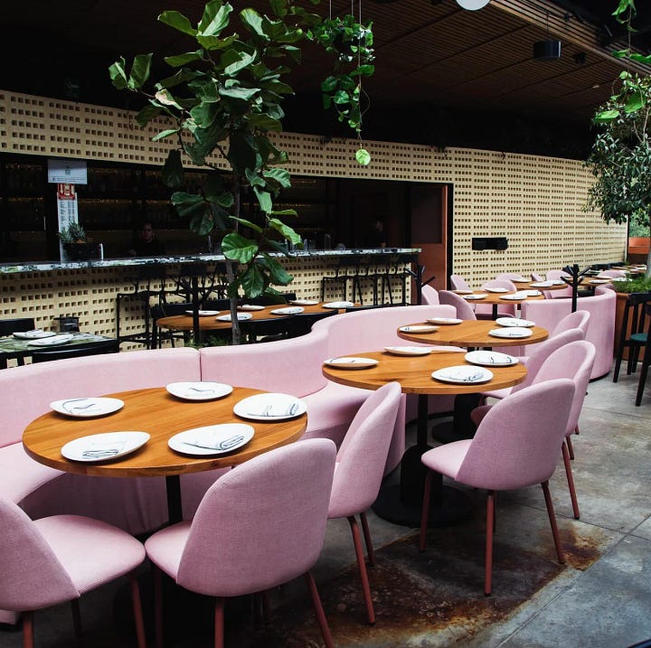 terraza bar en CDMX con sillones y barra para sentarse. Cocktail servido en un vaso sobre la mesa.