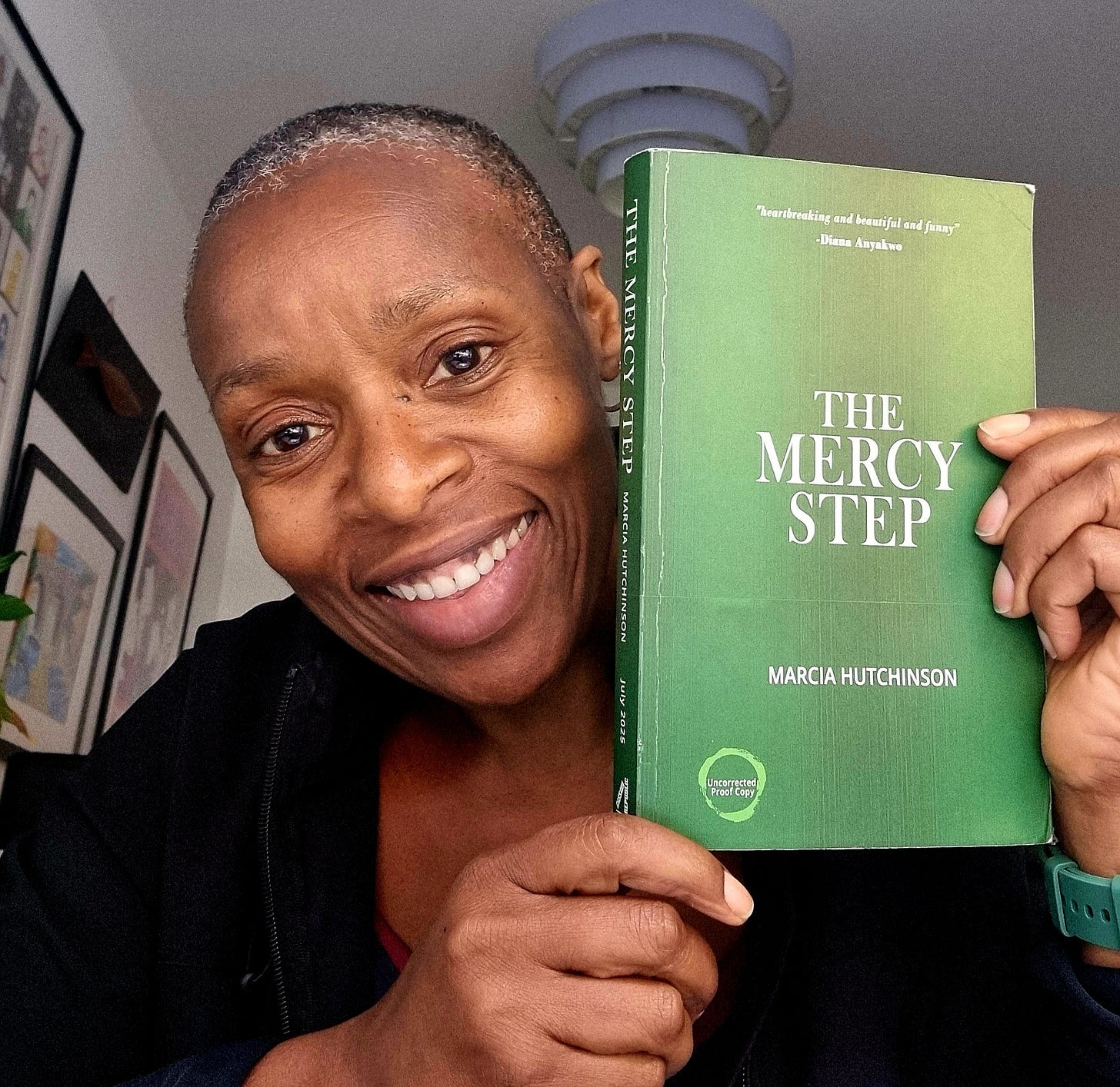 Marcia Hutchinson holding a copy of The proof copy of The Mercy Step her debut solo novel.