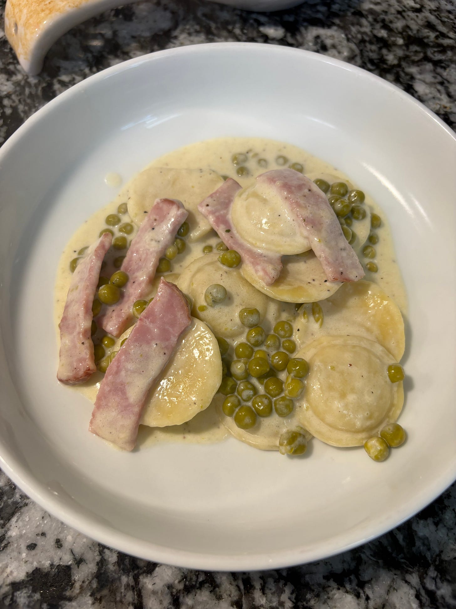 The finish dish of Ravioli Alfredo in a white bowl The finish dish of Ravioli Alfredo in a white bowl